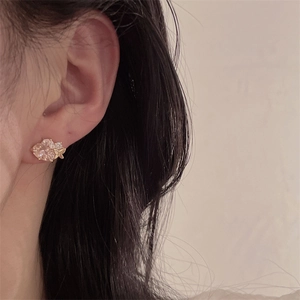 Detailed close-up of a vintage pink gemstone earring featuring a delicate gold butterfly
