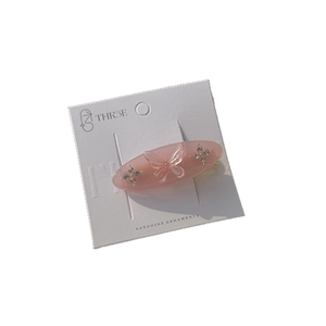 Pink translucent acetate butterfly hair clip with rhinestones on display card