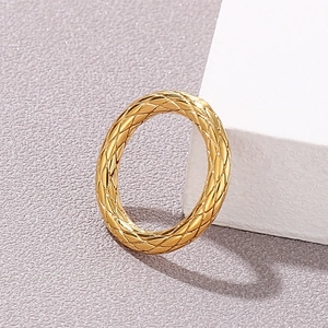 Close-up of golden stainless steel ring featuring detailed diamond grid engraving