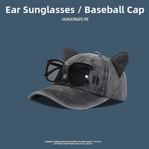 Detail of grey washed denim baseball cap featuring 3D cat ears and black square sunglasses