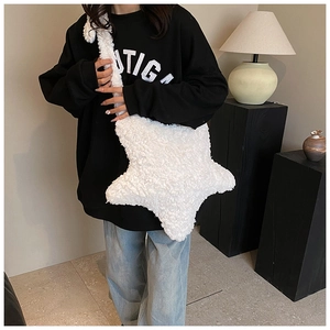 Close-up of white plush star-shaped crossbody bag featuring soft faux fur texture