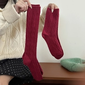 Gros plan de chaussettes en laine rouge tricotées montrant la texture chaude et épaisse