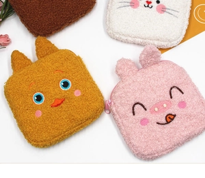 Detail of plush animal-shaped pouches with embroidered faces and soft fleece texture