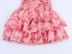 Detalle de vestido rosa de capas con volantes, texturas florales y cintura elástica fruncida