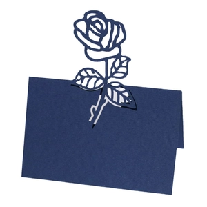 Detail of laser-cut rose hollow design on dark blue wedding place card stationery