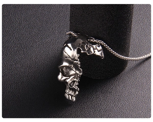 Gros plan du pendentif crâne punk en acier inoxydable sur fond en cuir litchi noir