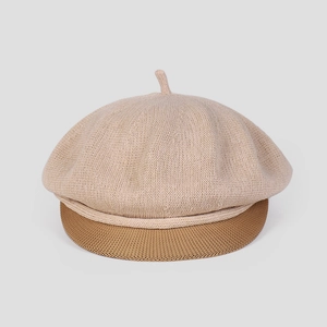 Détail du béret en maille contrastée montrant la texture beige et la visière kaki