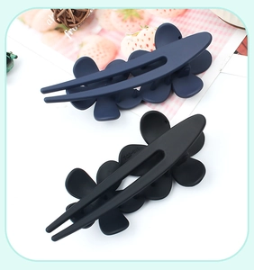 Detail of navy and black floral hair clips with a matte finish and U-shaped design