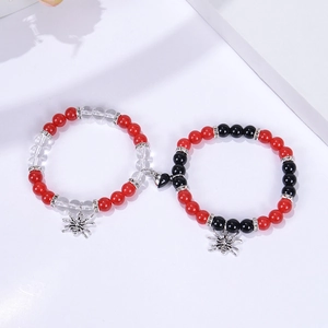 Magnetic spider couple bracelets with red and black beads and a heart magnet connector