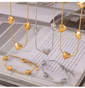 Detail view of heart pendant necklaces and bracelets in gold and silver snake chain sets