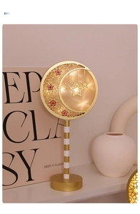 Close-up of golden moon and star LED lamp with warm lighting for festive home decor