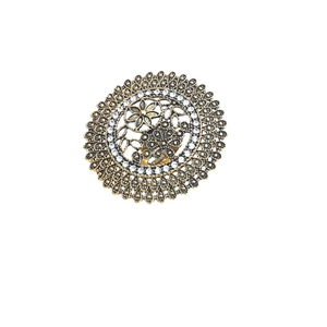 Detail of vintage bohemian hollow gold ring with intricate floral patterns and white diamonds
