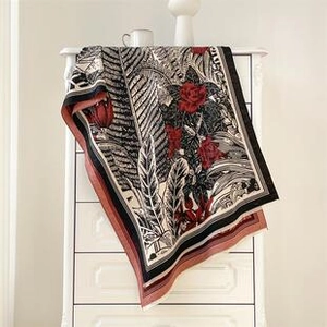 Close-up of ethnic lotus jacquard scarf showing black leaves and red rose patterns