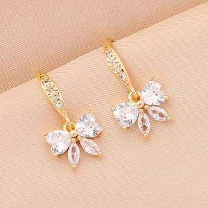 Elegant gold butterfly earrings with sparkling cubic zirconia on champagne silk fabric