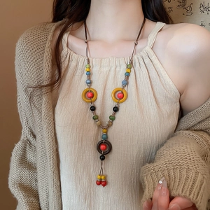 Detailed view of hand-woven ethnic ceramic beads and wooden rings on a bohemian necklace