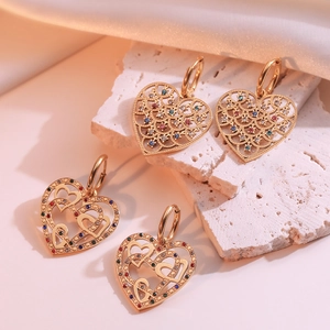 Vintage 18k gold plated heart earrings with colorful zircon stones on stone background