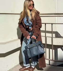Détail d'un sac à main en cuir bleu foncé avec forme trapèze et poignée classique