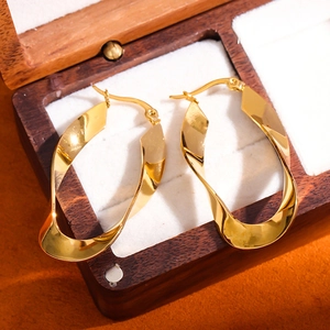 Polished 18K gold-plated U-shaped twisted metal hoop earrings in a wooden jewelry box