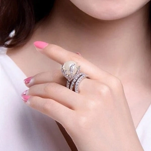 Detail of luxury pearl ring set with sparkling diamonds on a model hand