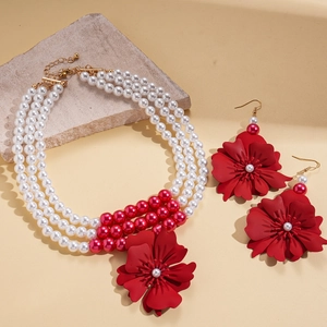 Three-layer faux pearl necklace set with bold red floral pendants and matching earrings