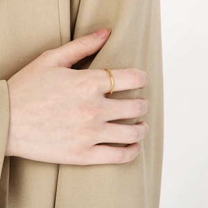 Detail eines minimalistischen, mattierten Edelstahlrings mit 18 Karat Goldbeschichtung.