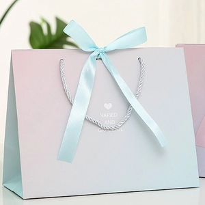 Gradient marble gift bag with ribbon handles and Varied and Graceful printed text