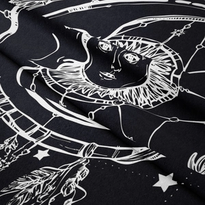 Detail of bohemian sun and moon tapestry fabric showing texture and soft draping