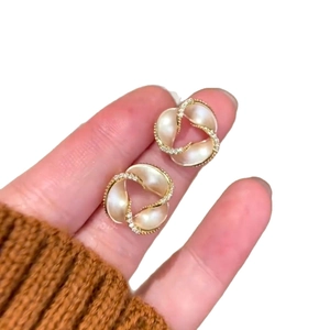 14K gold plated spiral flower earrings with pearls and crystals on hand model