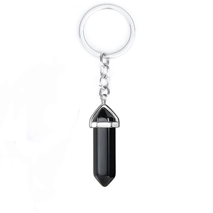 Detail view of a black onyx hexagonal prism pendant on a silver metal keychain