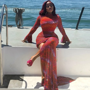 Slim fit long sleeve mini dress with warm tone prints and flared sleeves on a boat