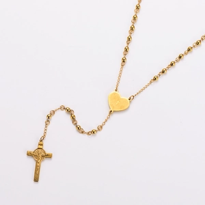 Detailed view of a golden stainless steel rosary necklace with cross and heart pendant