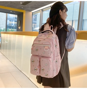 Detail of pink backpack with bear print featuring multiple functional zip pockets