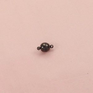 Detail of 8mm round spherical magnetic clasp in dark gray metal finish on pink fabric