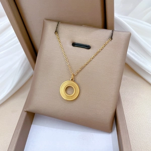 Macro view of gold rotating circle pendant with radial texture on silk background