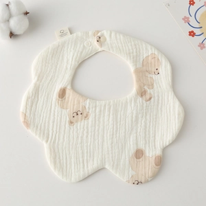 Detail of petal-shaped cotton baby bib with bear print and snap button closure