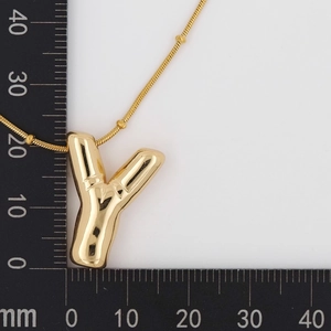Detail view of golden letter Y pendant with bamboo texture and bead snake chain on a white background
