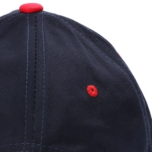 Detailed close-up of navy cotton baseball cap top with red button and eyelet stitching