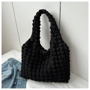 Close-up of black pleated puffer shoulder bag, featuring unique bubble texture and large capacity.