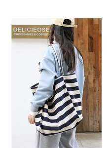 Navy and white striped canvas tote bag shown from a side-rear angle on a model