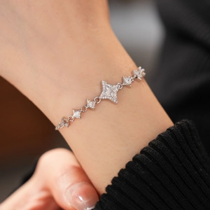 Detailed close-up of a silver star-shaped bracelet with cubic zirconia on a wrist