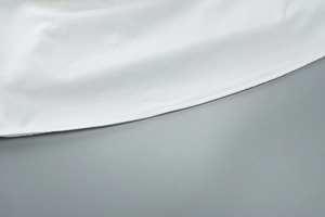 Gros plan détaillé montrant les coutures fines et la texture douce en coton de l'ourlet