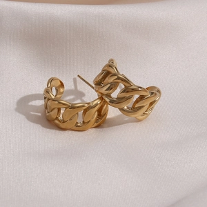 Polished gold curb chain C-shape hoop earrings on premium cream silk background