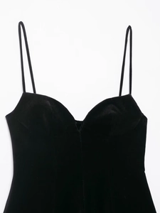 Détail du décolleté en V en velours noir et des fines bretelles de la robe