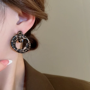 Close-up of vintage leopard print double hoop earrings worn by a stylish model