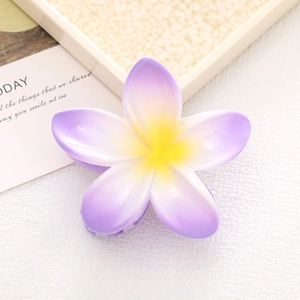 Macro detail of the purple gradient plumeria hair claw clip with a yellow center
