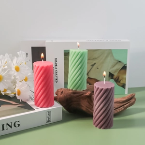Detailed view of spiral textured pillar candles in pink, green and purple colors