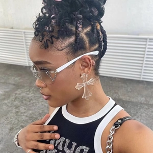 Close-up of large transparent resin cross earrings worn by a model in streetwear style