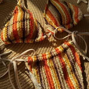 Bikini chic à rayures multicolores en tricot texturé sur une natte de plage