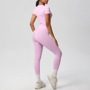 Detail of pink yoga set showing the sleek fabric texture and slim fit on a model
