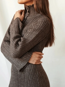 Nahaufnahme der braunen Stricktextur und Knopfdetails am Kragen des Kleides